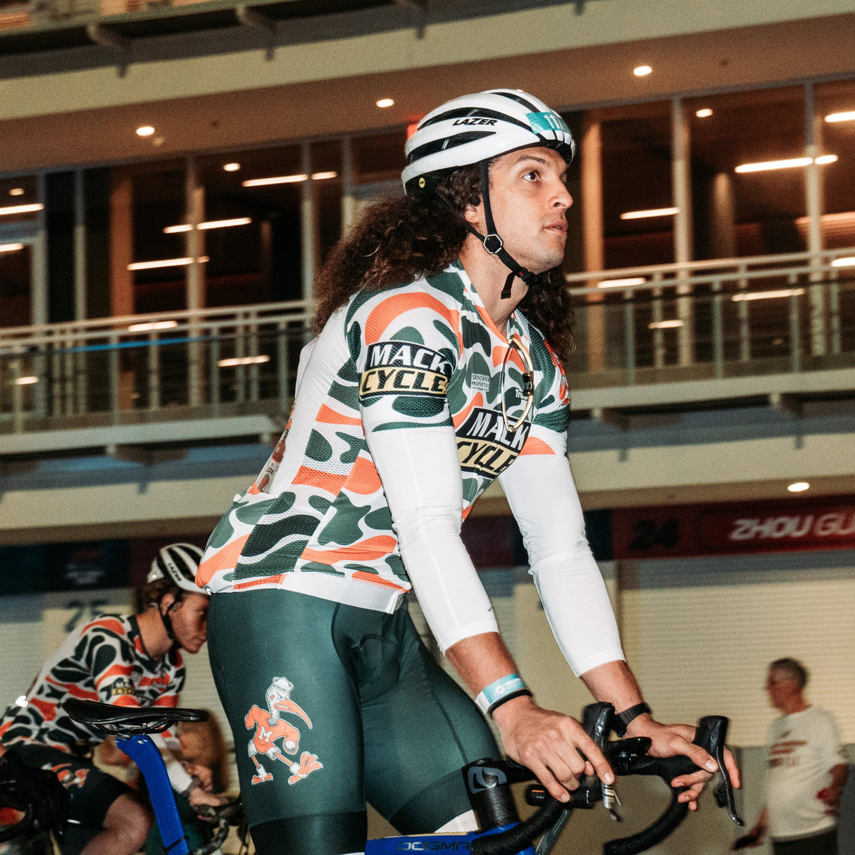 Mack Hollins, American football wide receiver for the Atlanta Falcons of the National Football League during the 2024 dolphin's challenge cancer 99 mile bike ride. He is wearing the Team Hurricanes Mack Cycle Goods by Dax Camo Jersey and Green Ibis bibs while Riding his blue Pinarello Dogma Bicycle