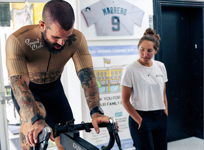 Scott Britton (ceo battle cancer) getting a guru bike fit from rachel at mack cycle. he is pictured wearing an assos gold speedclub jersey.
