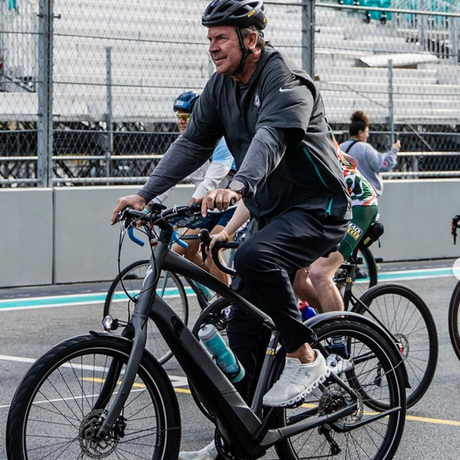  Dan Marino riding a Turbo Como from Mack Cycle during the Dolphins Challenge Cancer 2024, with the Formula 1 race track in the background.